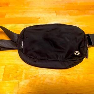 Lululemon Black belt bag with gold details.